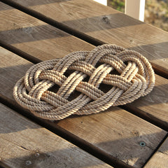 handmade tan ocean plait trivet on table