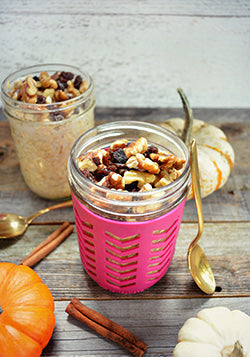 Pumpkin spice oatmeal topped with nuts and raisins in a mason jar.