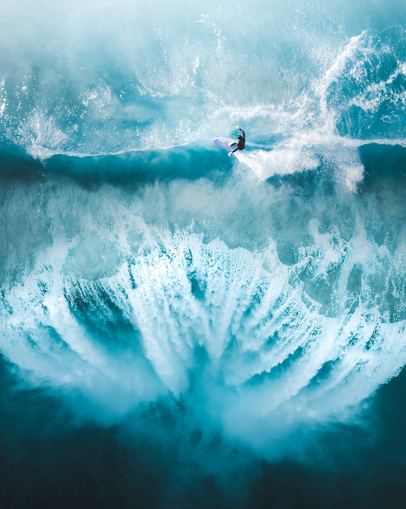 Phil de Glanville's photography aerial capture of a surfer by a waterfall in Australia