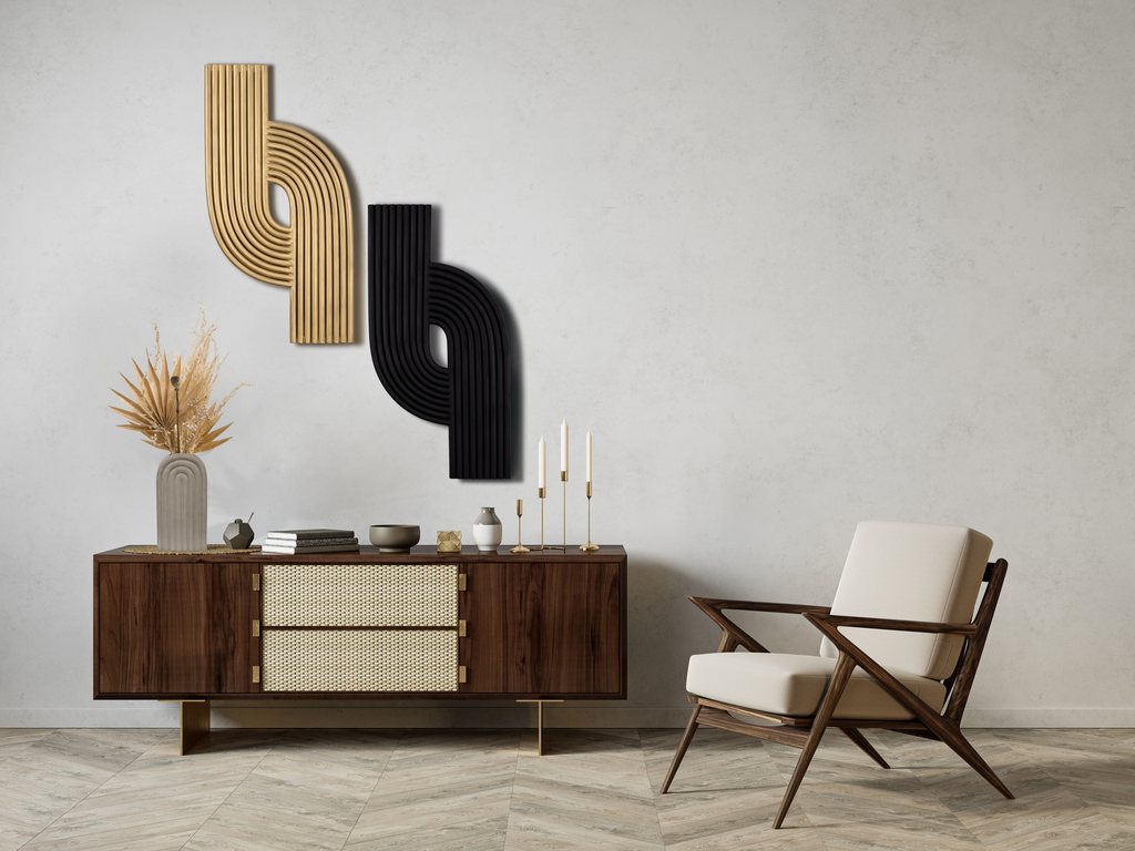Black and gold Bauhaus wall art pieces in front of a wooden console and armchair