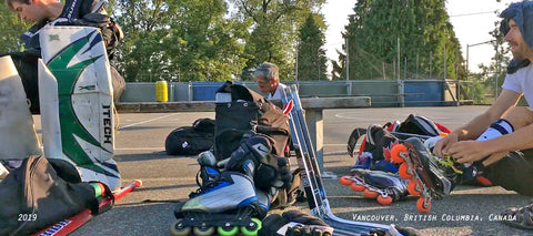 suiting up for outdoor street roller hockey in Vancouver BC at Queen Elizabeth Park. Marsblade and Bauer skates with some shafts and abs blades on the bench.