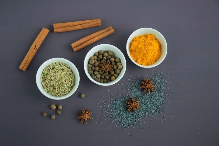 Assorted spices near white ceramic bowls