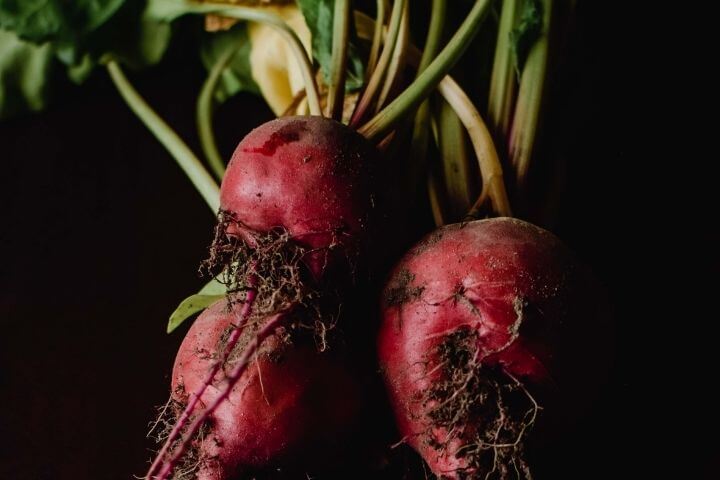A photo of two beetroots on a black background