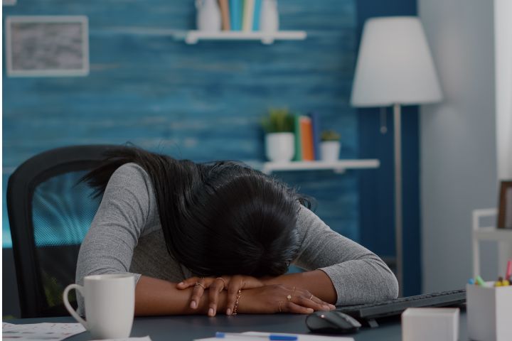 Disappointed Workaholic Student Sleeeping on Desk Table in Living Room after Working Remote from Home