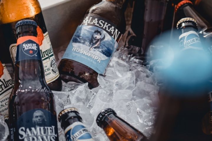 Samuel Adams beer bottles placed on a chest freezer filled with ice cubes