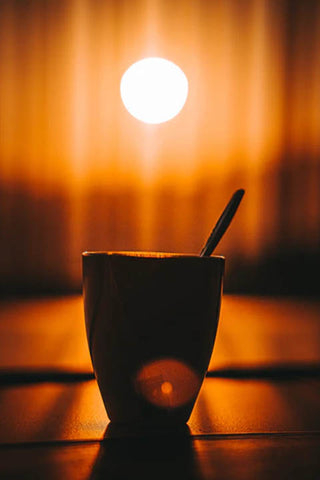 a cup of tea in front of a curtain early in the morning