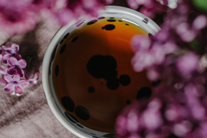 cup-of-drink-under-blooming-flower