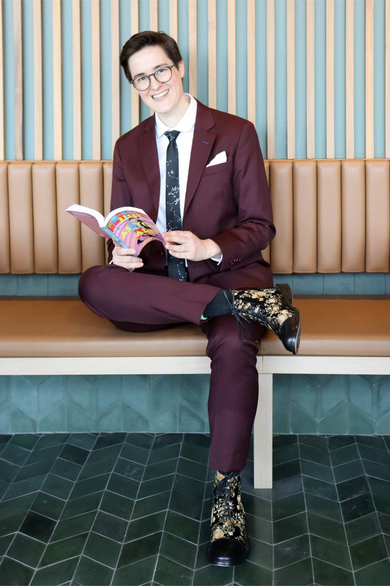 Non-binary suit in Burgundy worn by Camille Kellogg