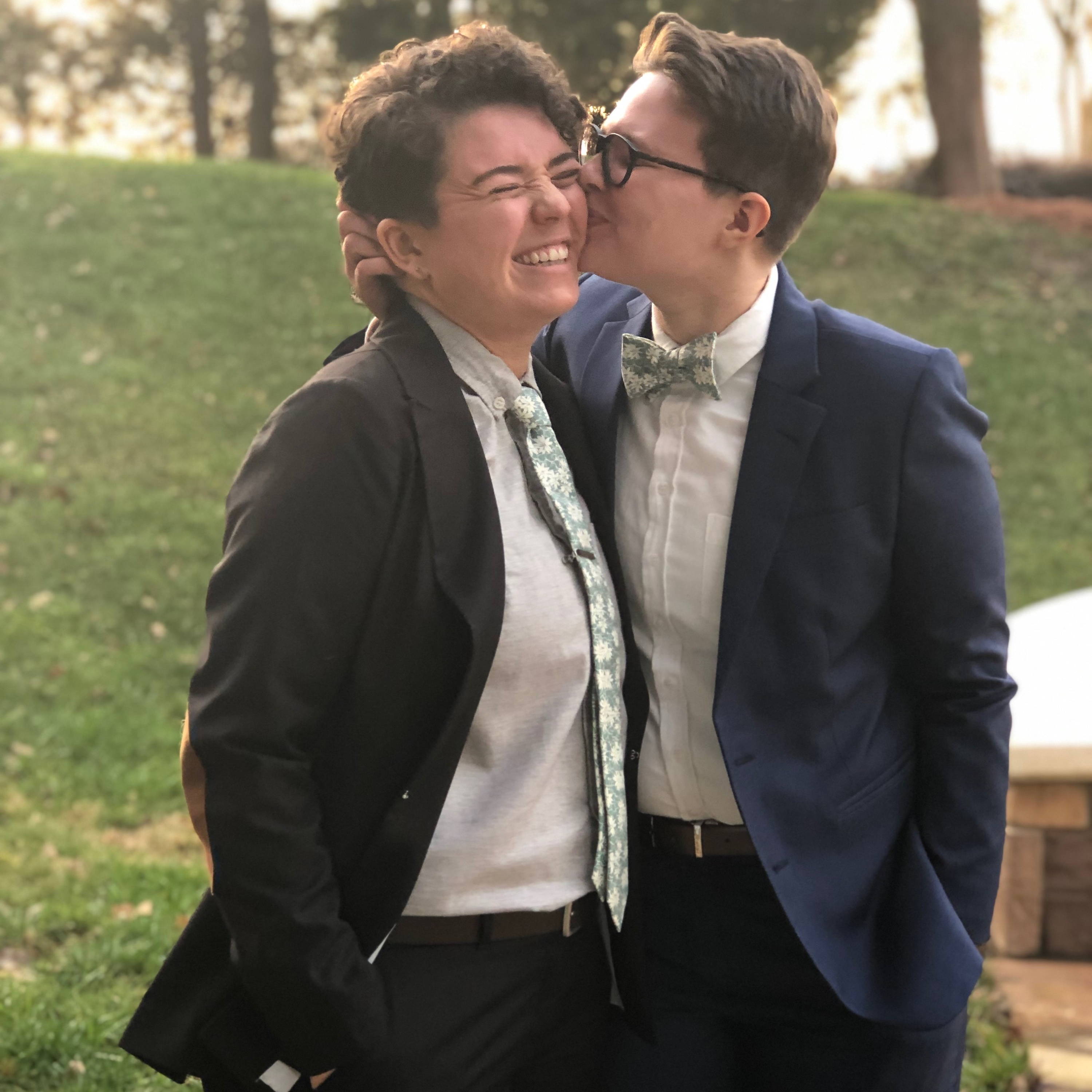 lesbian couple wearing navy and black suits 
