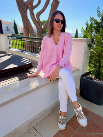 Girl sitting in light pink cashmere v neck sweater