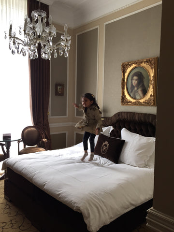 luxurious bedroom with jumping cute baby toddler girl
