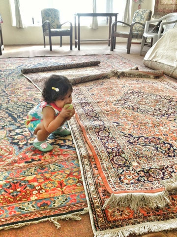 baby inspecting fine kashmir carpets 