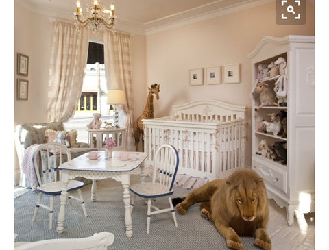 beautiful baby nursery with classic decor and oversized toys. 