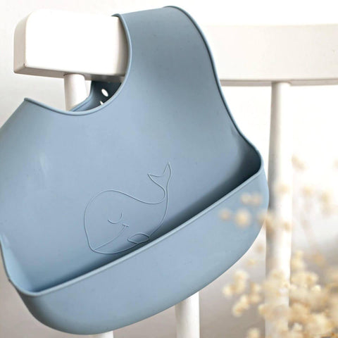 https://cdn.shopify.com/s/files/1/0981/5442/products/silicone_baby_bib_whale_blue_chair-2-2_large.jpg?v=1557693002