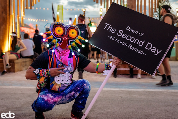 Owl Costume at EDC wearing neon owl head and bright galaxy print space joggers