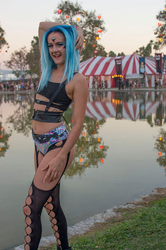 Raver with Blue Hair wearing black strappy top and trippy bottoms 