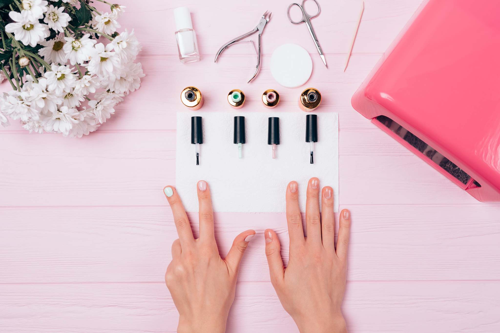 Female hands with manicure on a pink table