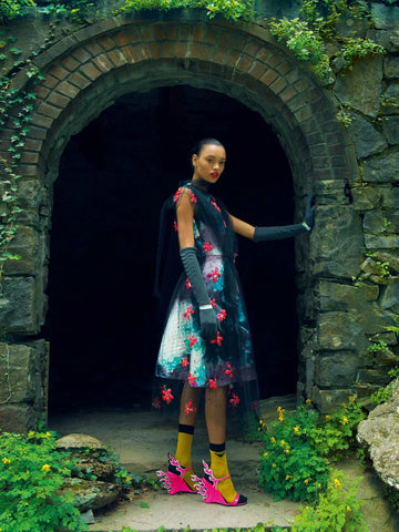 A model in vibrant colored outfit with hot-pink statement heels