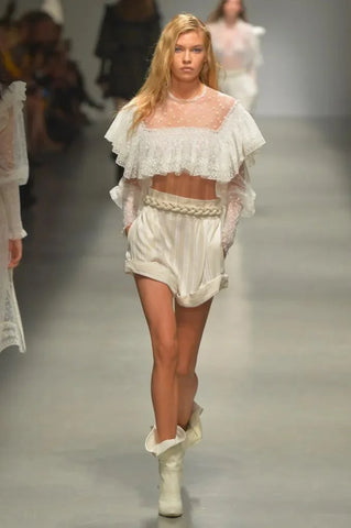 A model in a Paperbag Waist Shorts and Ruffled Blouse