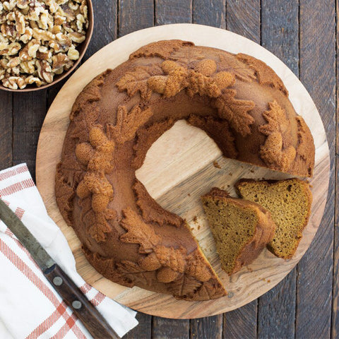 Bundt cake sitting on a table. The cake is imprinted with acorns and leaves.