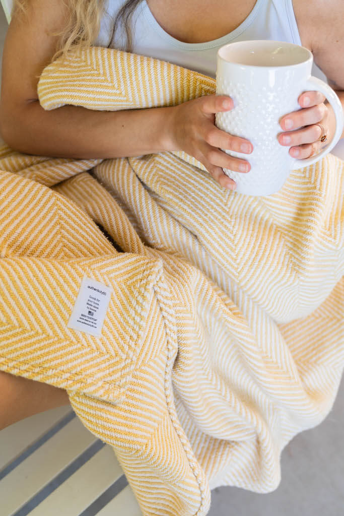 Prairie Yellow Cotton Heritage Blanket by Authenticity50, woman wrapped up with tea