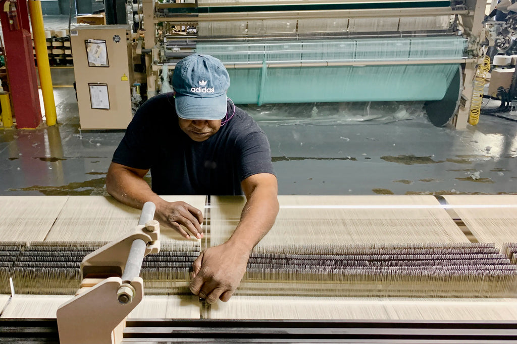 man working on weaving looms