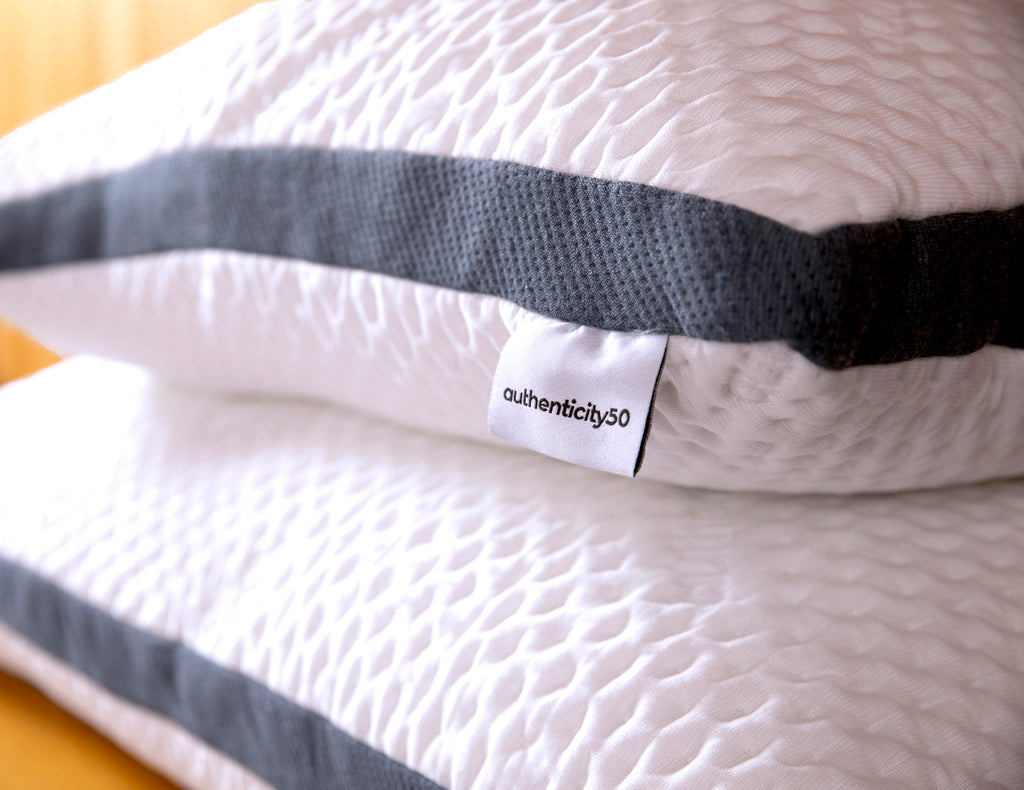 2 authenticity50 custom comfort pillows stacked on top of each other