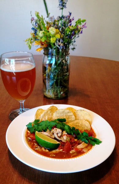 photo of a bowl of chicken tortilla soup with garnishes