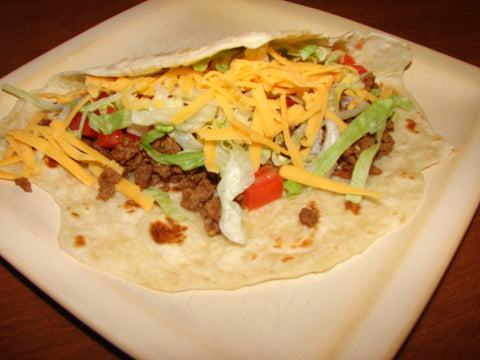 Prepared taco on plate with lettuce, cheese, tomato