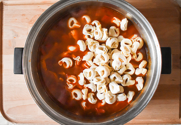 frozen cheese tortellini added into pot with soup