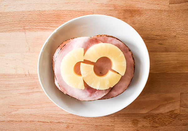 sliced pineapple added to ham on provolone on bread