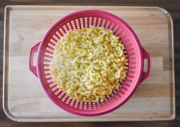 cooked macaroni noodles in colander