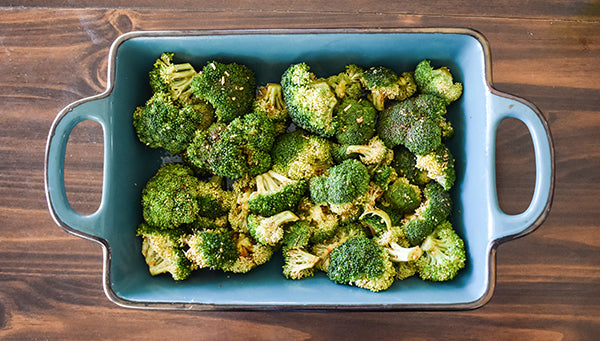 seasoned broccoli added to baking dish