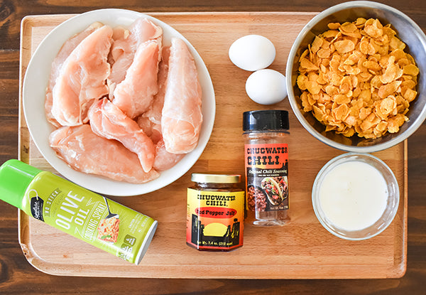 ingredients for sweet chili chicken tenders, thawed chicken tenders, egg, milk, corn flakes, chugwater chili seasoning, chugwater chili red pepper jelly, olive oil cooking spray