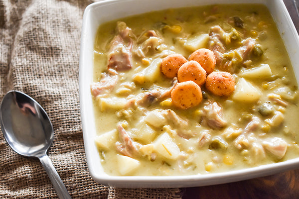 Green chile chicken and corn chowder in bowl with chugwater chili ranch flavored crackers on top