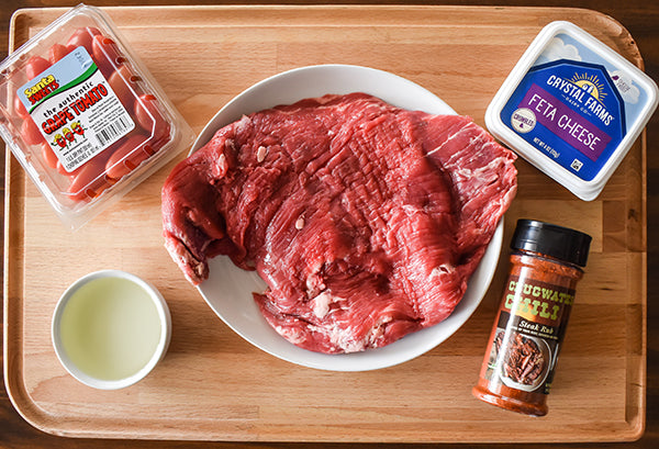 Ingredients for flank steak sandwich on a cutting board