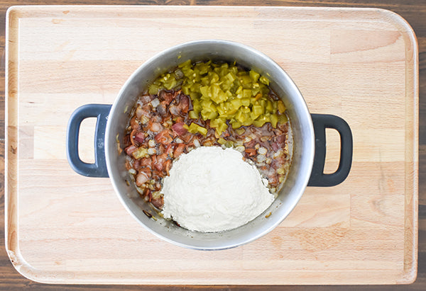 diced green chilies and flour added to cooked bacon and onion to create roux