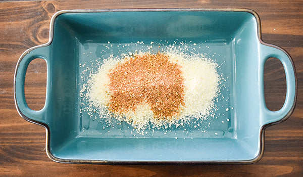 Parmesan cheese and chugwater chili dip and dressing mix on bottom of baking dish