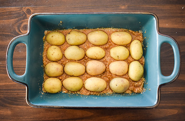 potatoes pressed face down into butter parmesan mixture