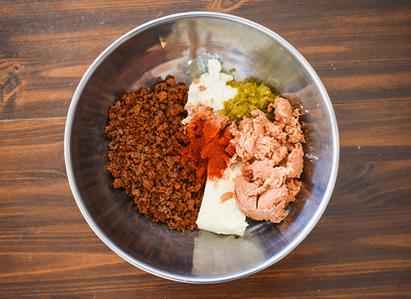 seasoned ground beef, cream cheese, sour cream, refried beans, diced green chilies, and chugwater chili seasoning added to mixing bowl to be mixed together