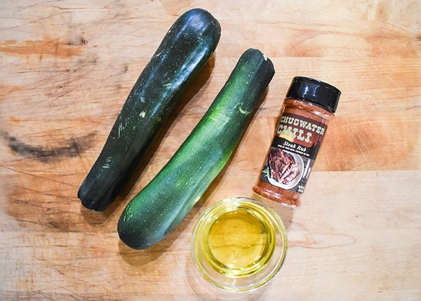 2 medium zucchini, chugwater chili steak rub, and olive oil on cutting board