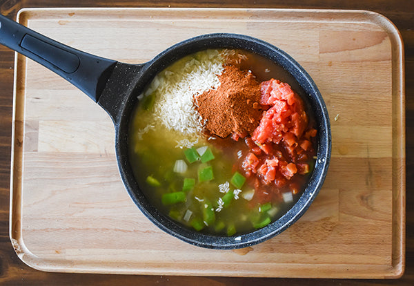 chicken broth, rice, diced tomatoes with green chilies, and chili seasoning added to skillet