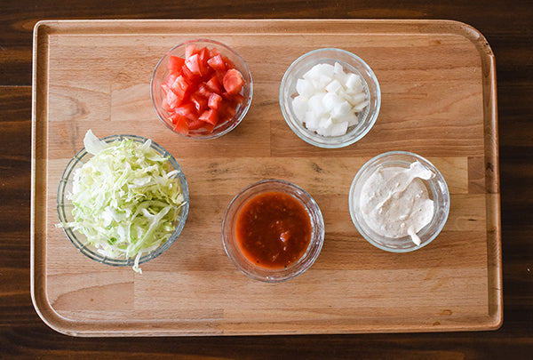 some nacho toppings, lettuce, tomatoes, diced onion, salsa, and chugwater chili dip