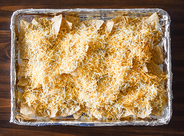 Shredded cheese added to the top of the tortilla chips