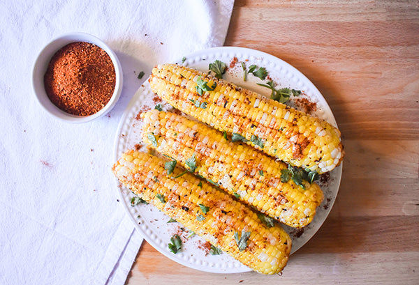 Chugwater Chili Steak Rub Spicy corn on the cob on plate with cilantro 