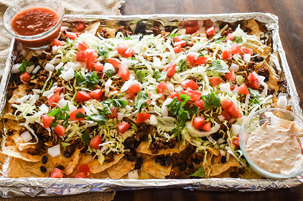 sheet pan nachos with toppings and dips