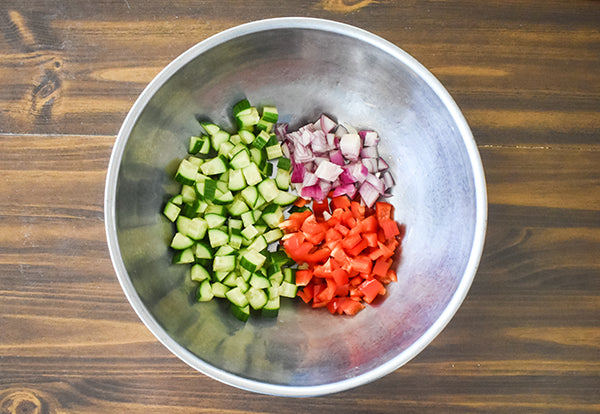 diced cucumber, diced red bell pepper, and diced red onion in bowl