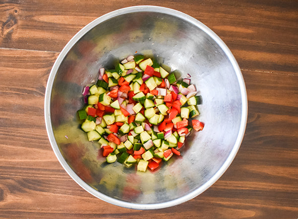diced red onion, cucumber, and red bell pepper in bowl