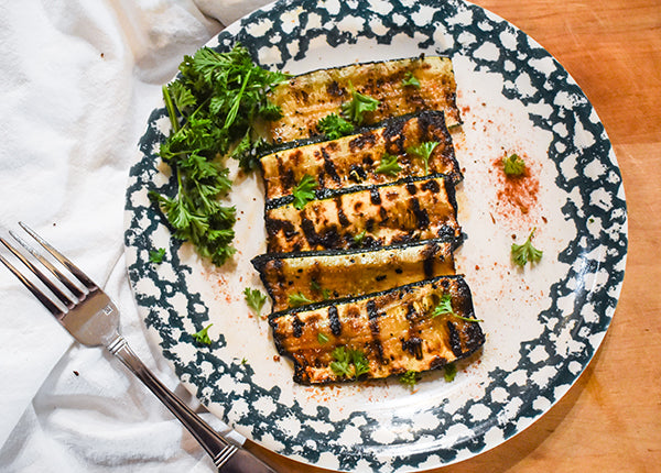 spicy grilled zucchini on plate garnished with parsley