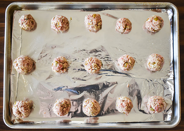 green chile sausage balls on baking sheet ready to be cooked